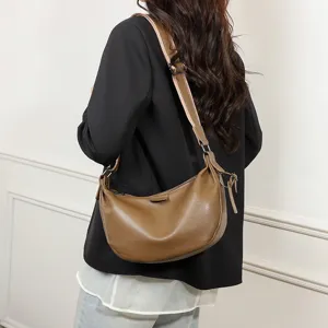 Detailed view of a brown leather hobo crossbody bag, casual commuting dumpling handbag style.