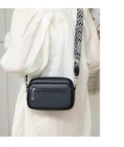 Vue détaillée du sac bandoulière en cuir noir avec large sangle et double fermeture éclair.