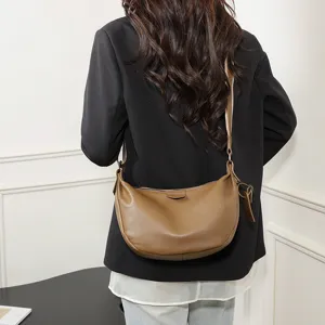Detailed view of the stylish brown leather shoulder bag, premium crescent dumpling design for women.