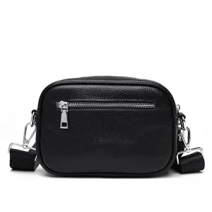 Detailed view of a black genuine leather women's crossbody bag with silver hardware and strap.
