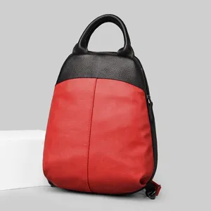 Details of the red and black leather backpack showcasing its shell shape, texture and double straps.