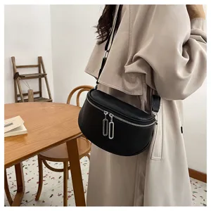 Genuine leather crescent crossbody bag detail view showing smooth texture and metal zippers.