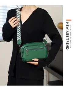 Sac bandoulière en cuir vert avec sangle large, vue détaillée montrant la poche zippée élégante.