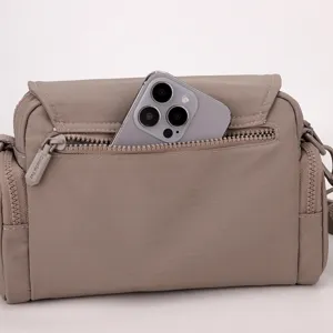 Detailed view of the lightweight casual crossbody bag showing multi-zipper pocket storage.