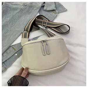 Detail shot of genuine leather saddle bag, contrast striped strap, metal dual zipper pullers.