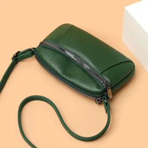 Dark green genuine leather crossbody bag for women, miniature dual zipper shoulder bag design.