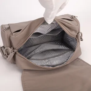 Close-up view of the nylon crossbody bag interior showing multiple zipper compartments.