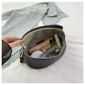 Detailed view of black leather saddle shoulder bag interior capacity with daily items.