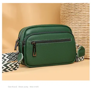 Vue détaillée du sac bandoulière en cuir véritable vert foncé avec large sangle.