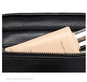 Détail de pochette pour homme en cuir véritable noir souple avec texture.
