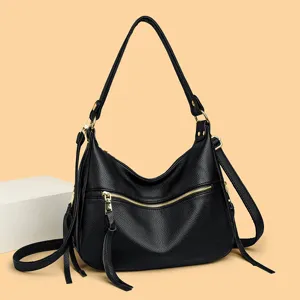 Black hobo shoulder bag with front zipper pocket, tassel details, and gold tone hardware.