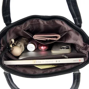 Interior detail view of black leather tote bag showing large capacity and pockets design.