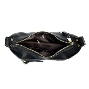 Detailed top view of the black leather crossbody bag showing interior compartments and gold zippers.