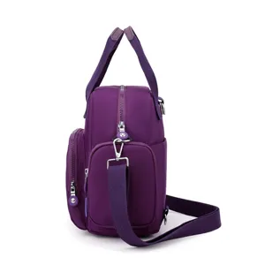 Side view of a purple nylon crossbody shoulder bag, showing durable straps and metal hardware.