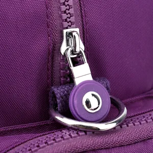 Close-up detail of purple nylon backpack zipper hardware and durable metal pull ring design.