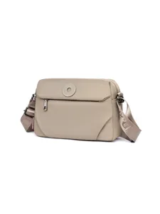 Detailed view of casual nylon crossbody bag with zipper pocket and stylish circular badge.