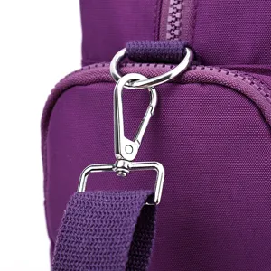 Close-up detail of purple nylon shoulder bag hardware, silver metal clasp and strap.