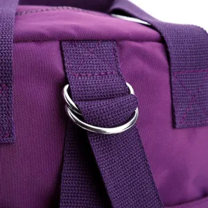 Close-up of purple nylon bag strap detail featuring metal D-rings and reinforced stitching.