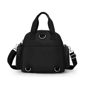 Close-up detail of the black nylon convertible backpack with multiple D-rings and side pockets.