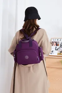 Detail view of a stylish purple nylon casual backpack featuring multiple functional pockets.