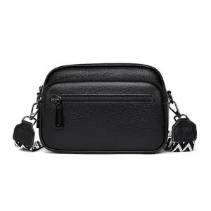 Sac bandoulière homme en cuir véritable noir avec sangle large à motif et poche zippée.