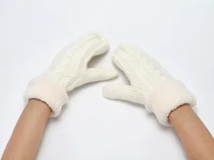 Close up detail view of soft cable knit winter mittens with warm plush fur cuffs.
