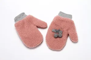 Winter warm fluffy pink mittens detail shot showing soft fleece texture and cute bow decor.
