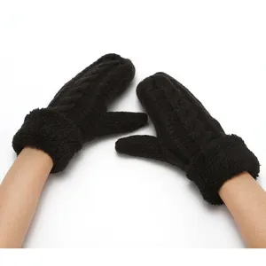Detailed close-up view of black thick knitted mittens with plush cuff for winter warmth.