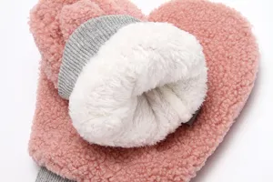 Close-up detail of cozy pink winter plush mittens with thick white fleece lining and grey cuffs.