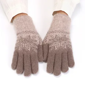 Detailed close-up of women's warm knit gloves with Nordic snowflake jacquard pattern.