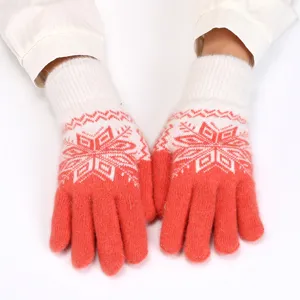 Close-up detail of women's red and white knitted winter thermal five-finger gloves.