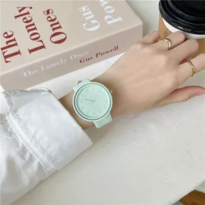 Close-up detail of mint green silicone strap quartz watch worn on wrist with minimalist dial.