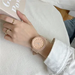 Detailed close-up of minimalist silicone watch worn on hand, featuring clean dial design.