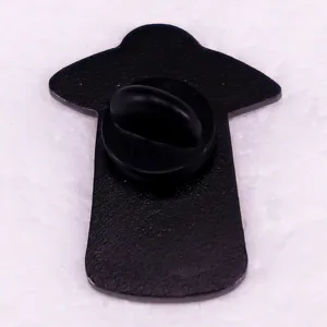 Close-up view of the back of a metal astronaut spaceship enamel pin with a black rubber clutch.