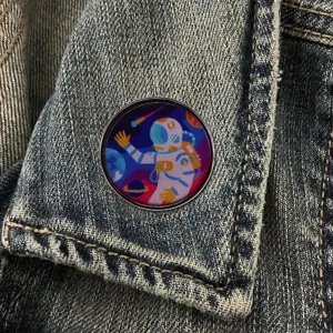 Space astronaut round metal badge pin, stylish cosmic design lapel accessory for denim jackets.