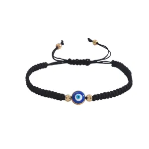 Bracelet en corde tressée noire mauvais œil avec breloque bleue et perles dorées.