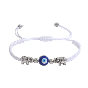Bracelet réglable en corde tressée blanche avec mauvais œil bleu et charmants pendentifs éléphants.