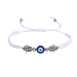 Bracelet tisse blanc reglable avec oeil turc bleu au centre et amulettes main de Fatima argentees.