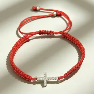 Bracelet en corde tissée rouge avec pendentif croix en cristal étincelant, réglable.