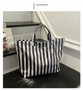 Detail view of a black and white striped PVC tote bag, showcasing texture and large capacity.