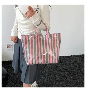 Detailed view of the colorful striped PVC tote bag, showcasing shiny waterproof texture.
