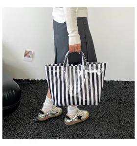 Transparent PVC striped tote bag, large capacity waterproof handbag for commuting and travel.