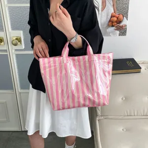 Stylish pink striped PVC tote bag, large capacity waterproof handbag for women daily commute.