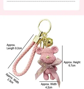 Mignon porte-clés ours tressé avec lanière rose et nœud, superbe accessoire de sac.