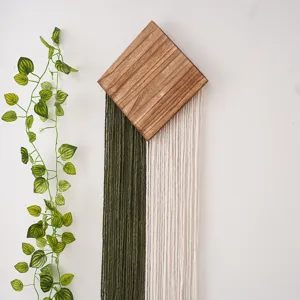 Vue détaillée de la planche en bois en losange avec décoration murale en franges macramé.