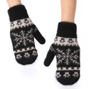 Close-up detail of winter warm fuzzy rabbit hair knit mittens with classic snowflake pattern.
