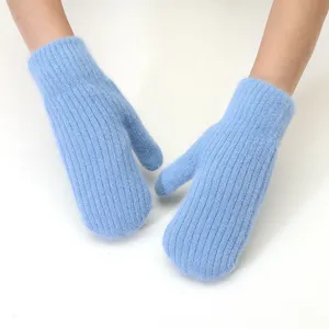 Close-up of fluffy winter warm knitted mittens, soft cozy plush fabric texture details.