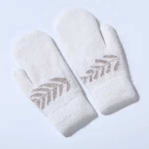 Close up view of white fluffy plush mittens with brown leaf pattern for winter warmth.