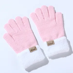 Close-up detail van gebreide dames winterhandschoenen met roze lichaam en pluizige witte boorden.