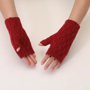 Close up of red knit fingerless gloves showing the warm textured winter wool fabric design.